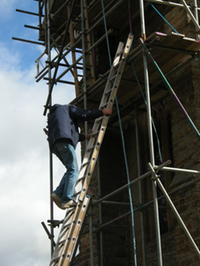 Man climbs ladder up to spire.
